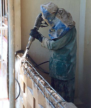 Ein Arbeiter beim Sanieren einer Mauer.