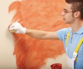 Wischtechnik: Ein Maler tupft Farbe mit einem Schwamm auf eine Wand.